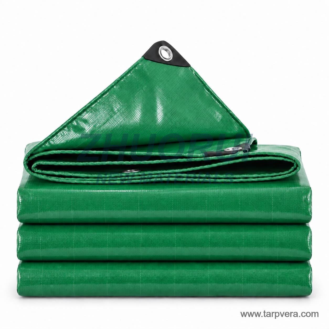 Folded green PVC tarpaulin showing eyelets and reinforced corners