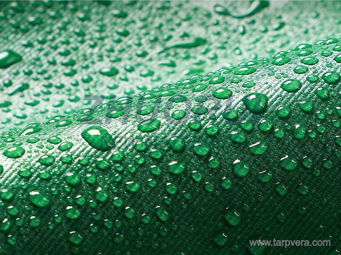 Water droplets beading on green PVC-coated fabric