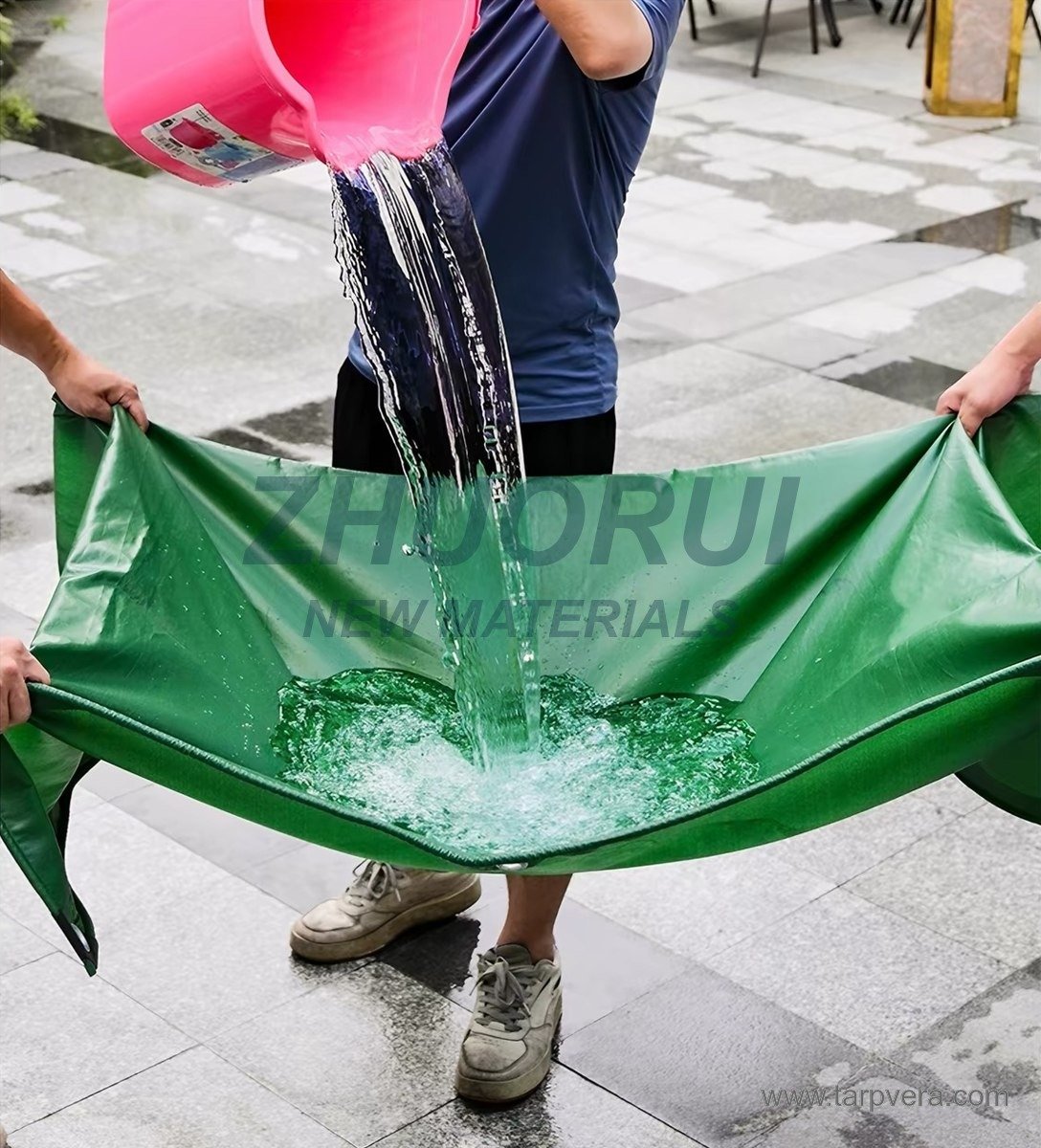 Water being poured onto a green PVC tarpaulin held at the corners